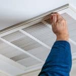 A person is working on a ceiling air conditioner